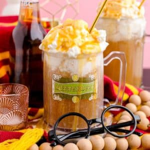 Square image of Butterbeer in glass with props around it.