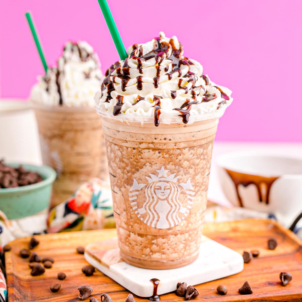 Java chip frappuccino in a Starbucks cup with whipped cream and drizzled chocolate sauce.