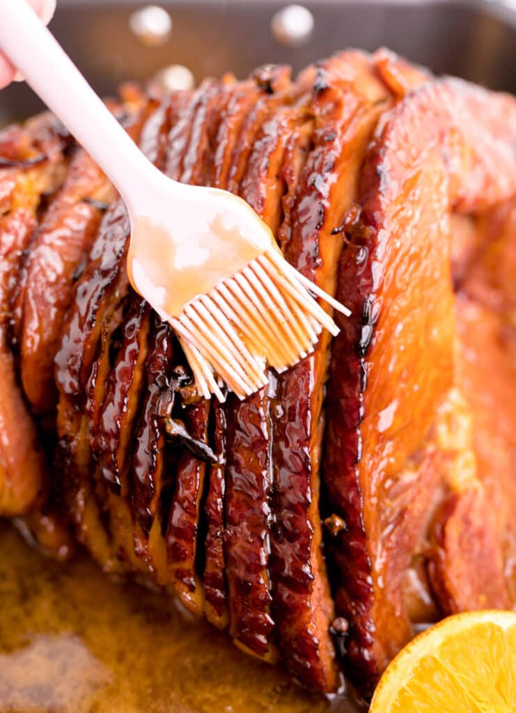 Close up image of a ham roast being glazed