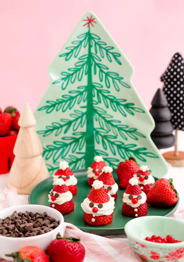 Seven Strawberry Santas on a green plate 