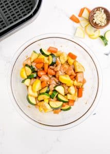 Squash, zucchini and chicken mixed together in a bowl with hibachi sauce.