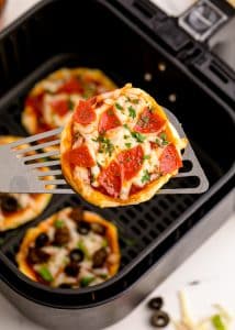 Air fryer pepperoni pizza on a spatula.
