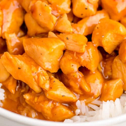 Orange chicken cooked in a slow cooker served over white rice.