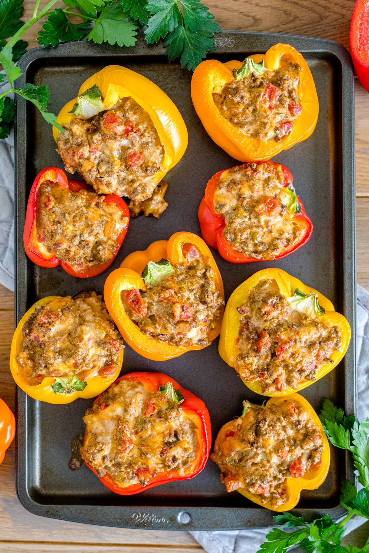 Cream cheese stuffed bell peppers baked and sitting on a baking sheet.