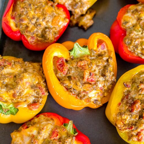 Cream cheese stuffed bell peppers baked on a baking sheet.