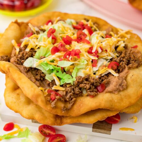 Indian fry bread tacos topped with ground beef, cheese, lettuce and tomatoes.